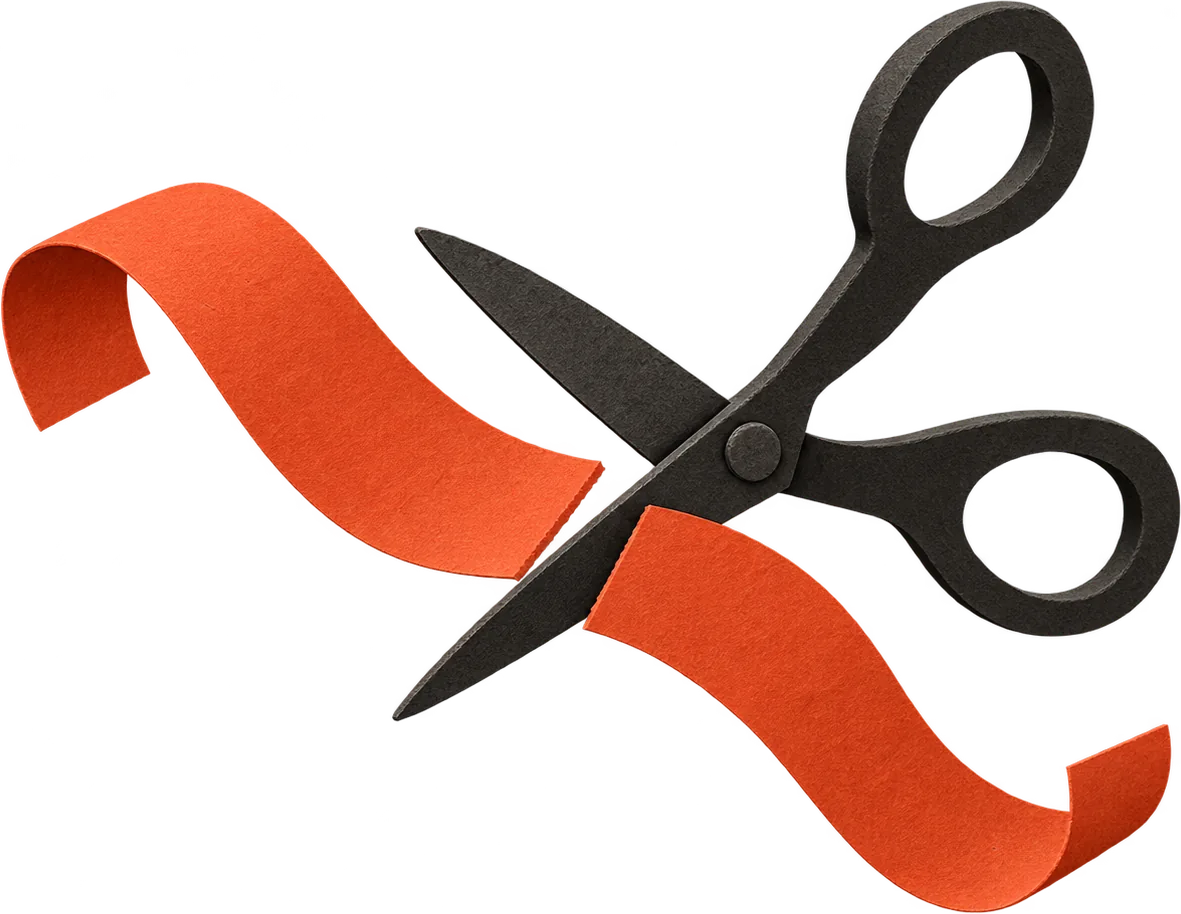 A pair of black paper scissors cutting a strip of red paper tape in two